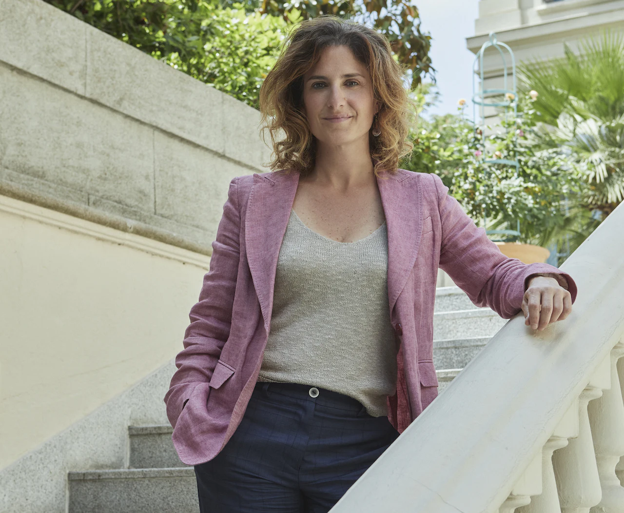 Portrait d’une femme debout dans un escalier extérieur.