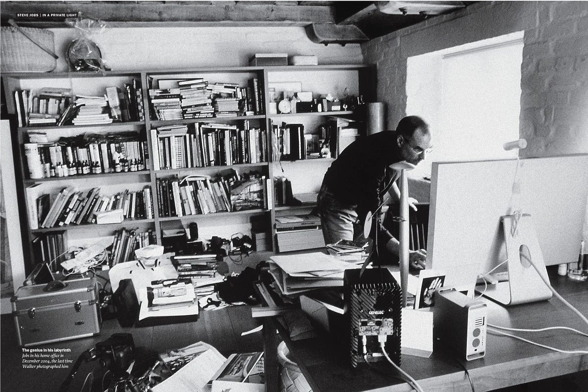Personne travaillant dans un bureau encombré de livres et de papiers.