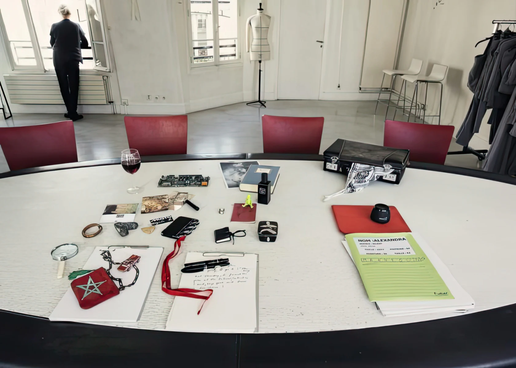 Objets et documents répartis sur une table de travail blanche.