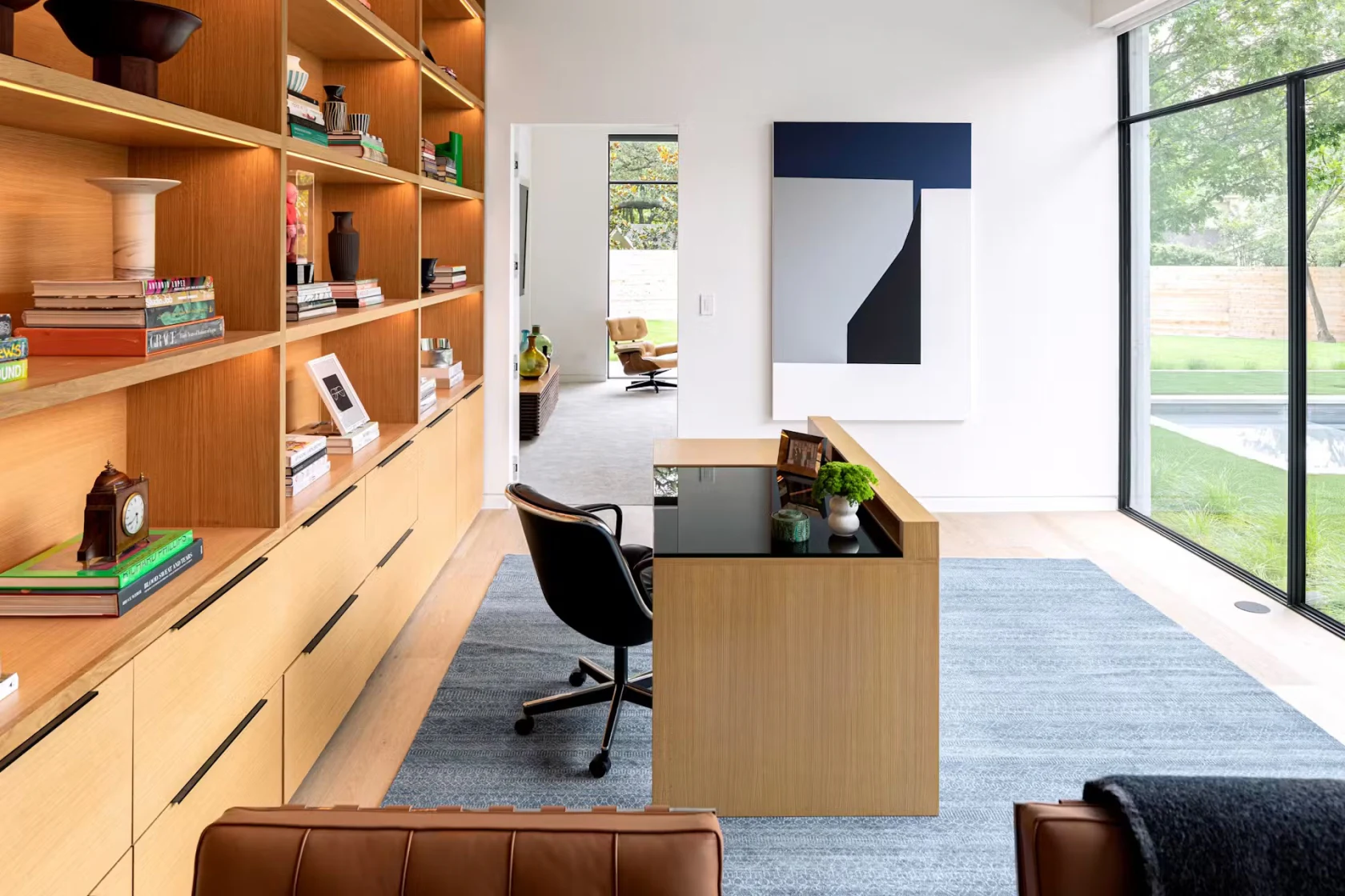 Bureau lumineux et rangé avec une bibliothèque en bois.