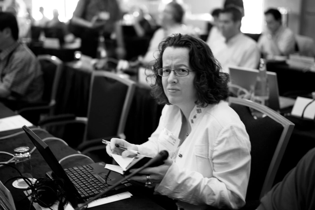 Genevieve Bell assise avec un ordinateur dans une salle de conférence.