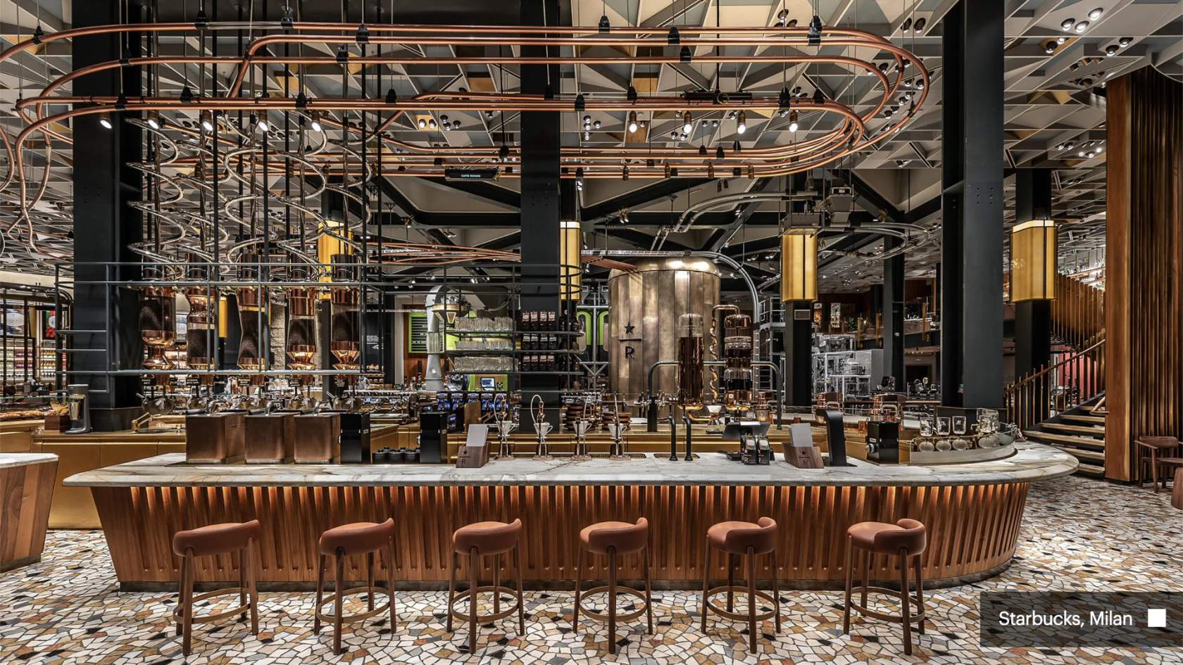 Intérieur du Starbucks de Milan avec son grand comptoir et ses installations de torréfaction.