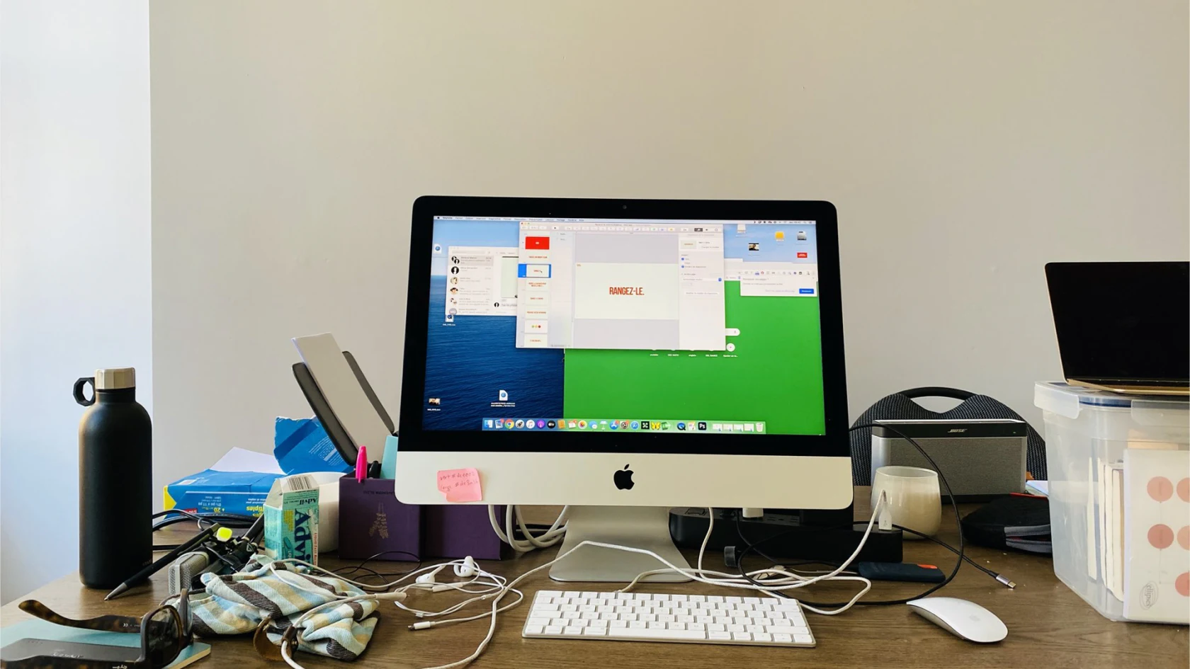 Ordinateur et accessoires sur un bureau encombré.