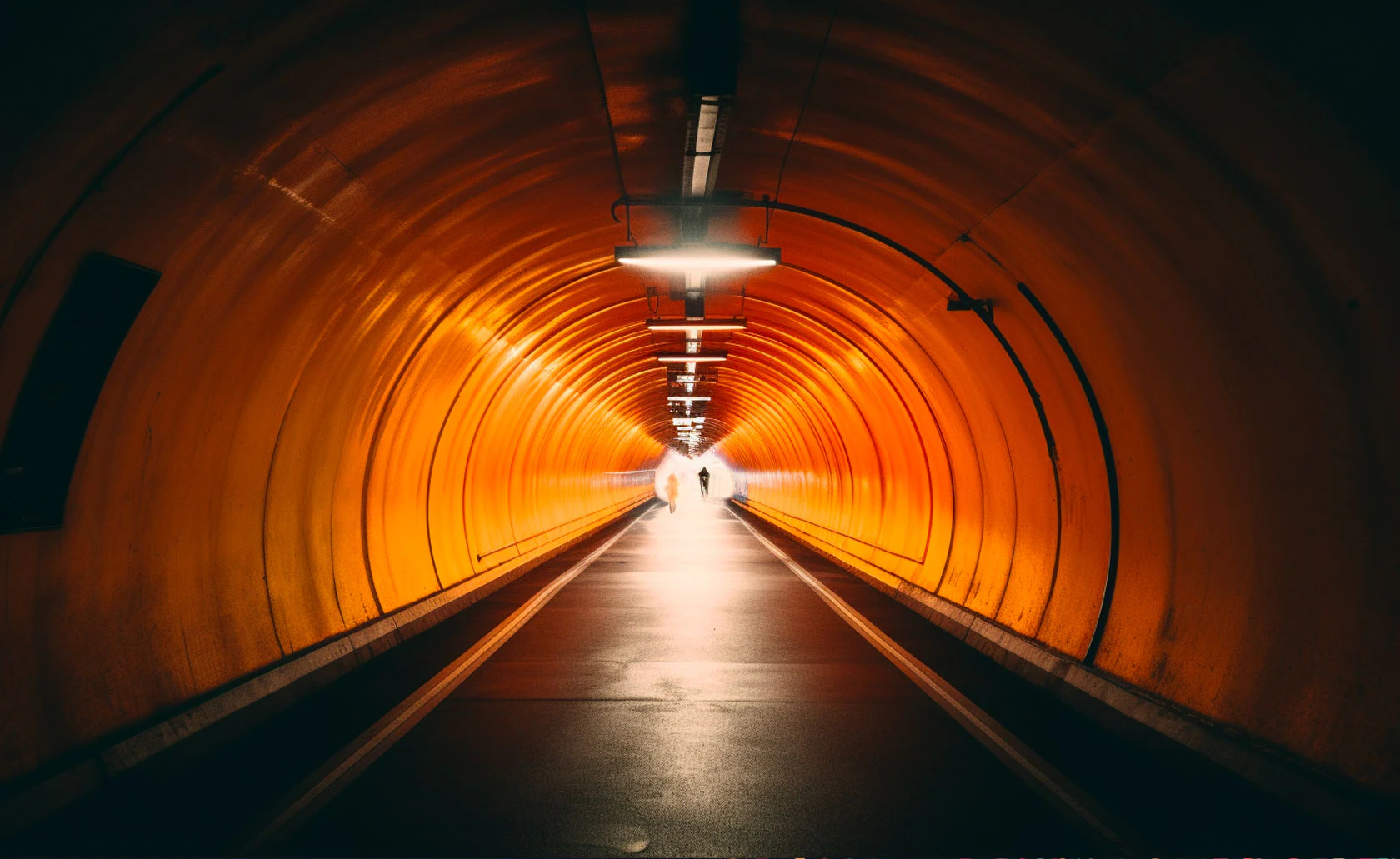 Long tunnel orange avec une sortie lumineuse.