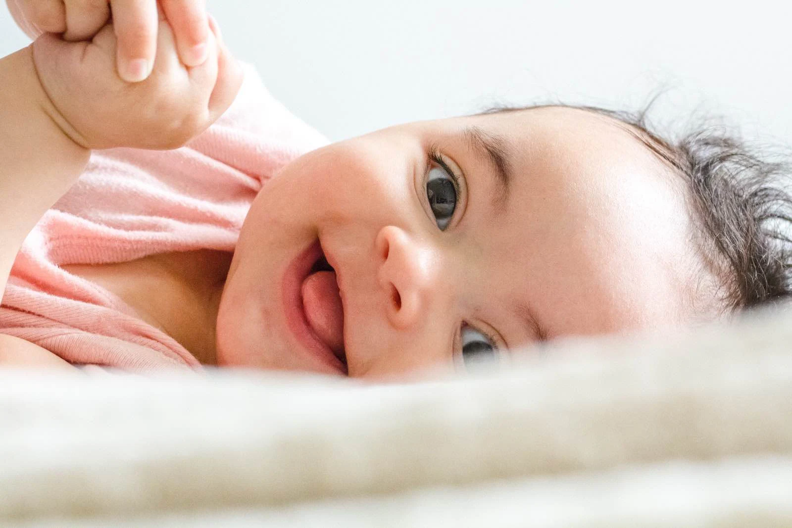 Bébé souriant couché sur le côté.