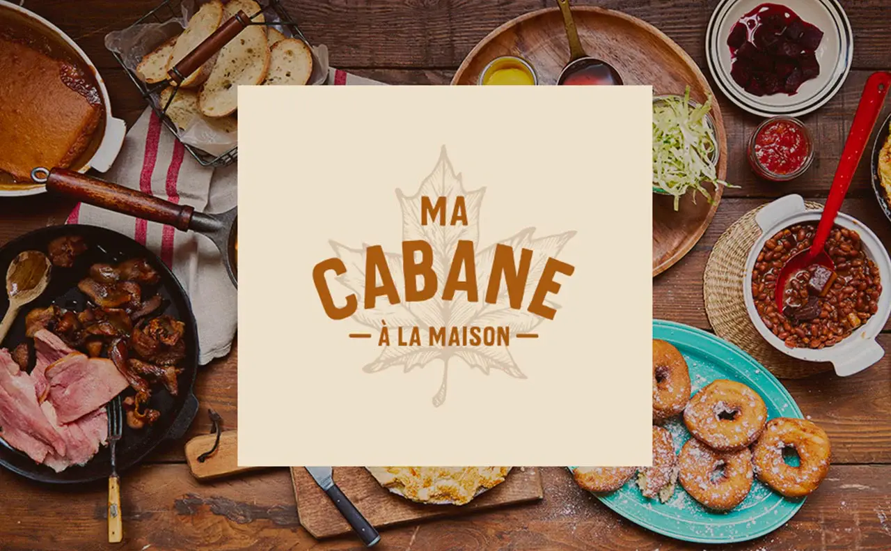 Offre Ma cabane à la maison présentée au milieu de plats de cabane à sucre.