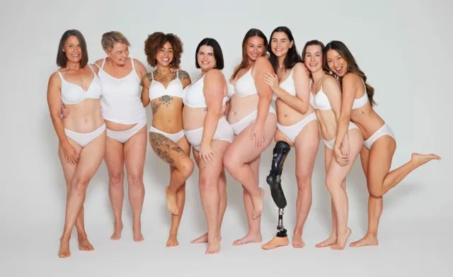 Groupe de femmes en sous-vêtements blancs, dont une porte une prothèse de jambe.
