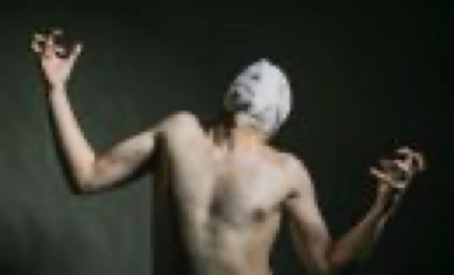 Homme torse nu, le visage recouvert d’un tissu.