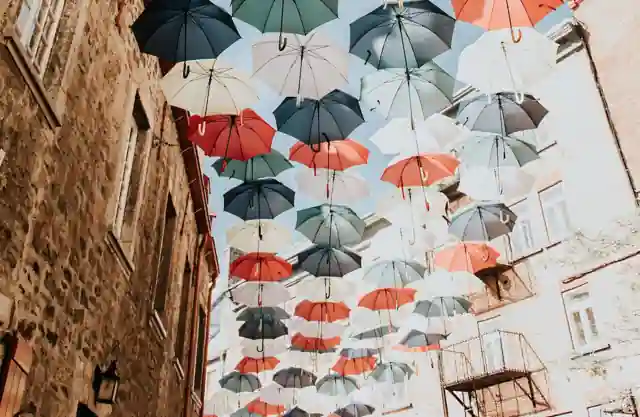 Parapluies colorés suspendus au-dessus d’une rue.