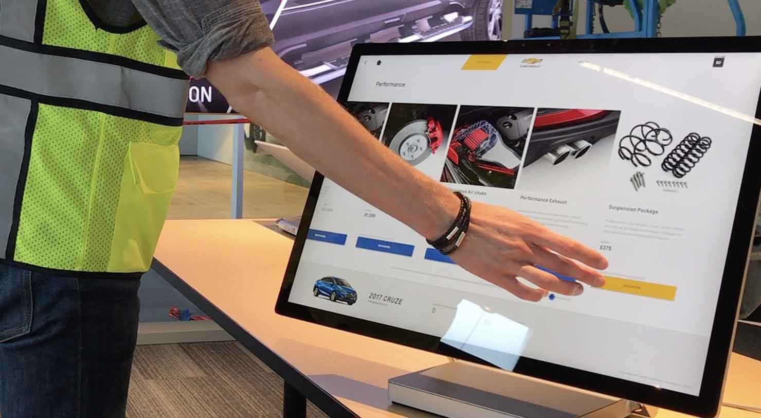 Large touchscreen of car accessories with person selecting an item with their hand