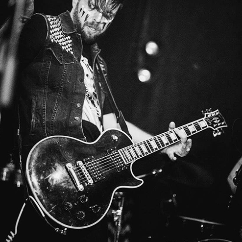 Michael Cobra playing guitar on stage