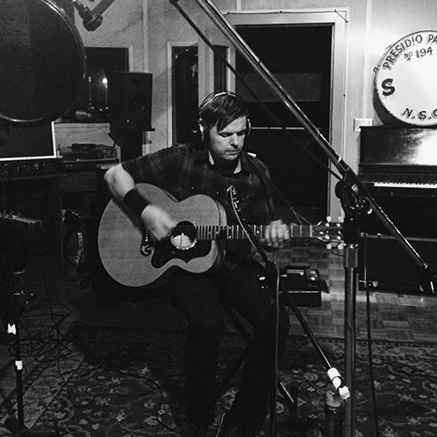 Michael Cobra playing guitar in recording studio
