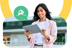 Smiling woman using a tablet outdoors with a green speech bubble icon featuring a house symbol.