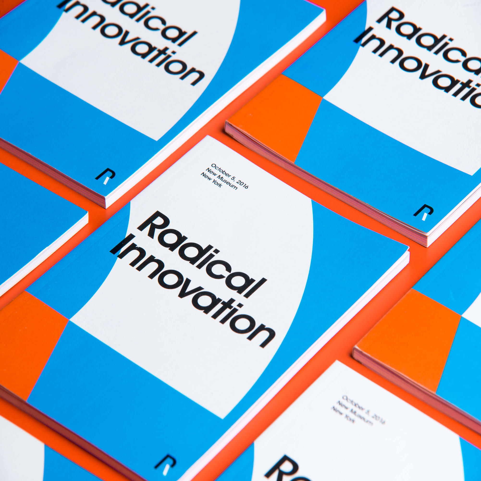 Books titled 'Radical Innovation' with a blue, white, and orange cover design arranged on an orange surface.