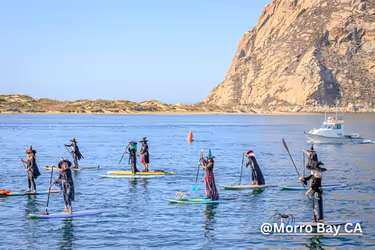People dressed as witches paddling in Morro Bay