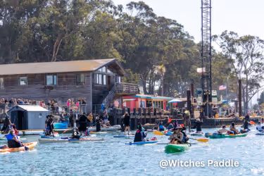 People dressed as witches in paddleboards