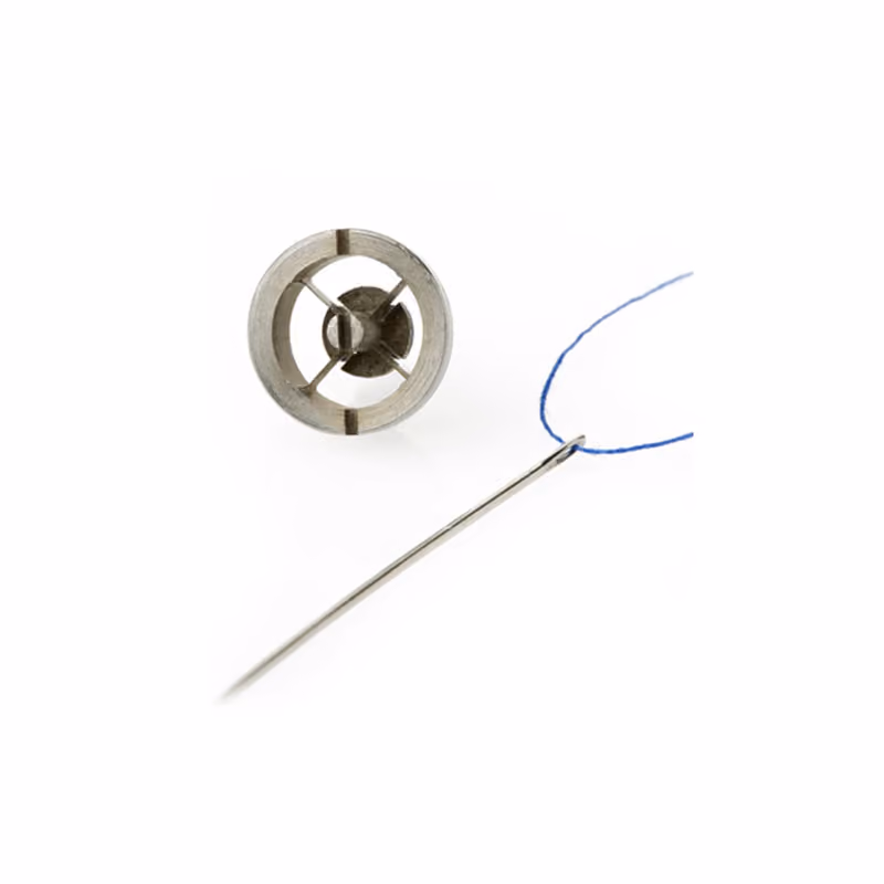 Tiny machined part shown next to a sewing needle for scale