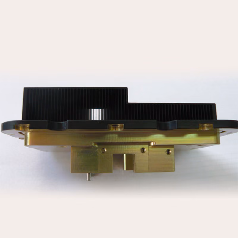 Close-up of a mechanical component with black fins and gold metallic base on a light background.