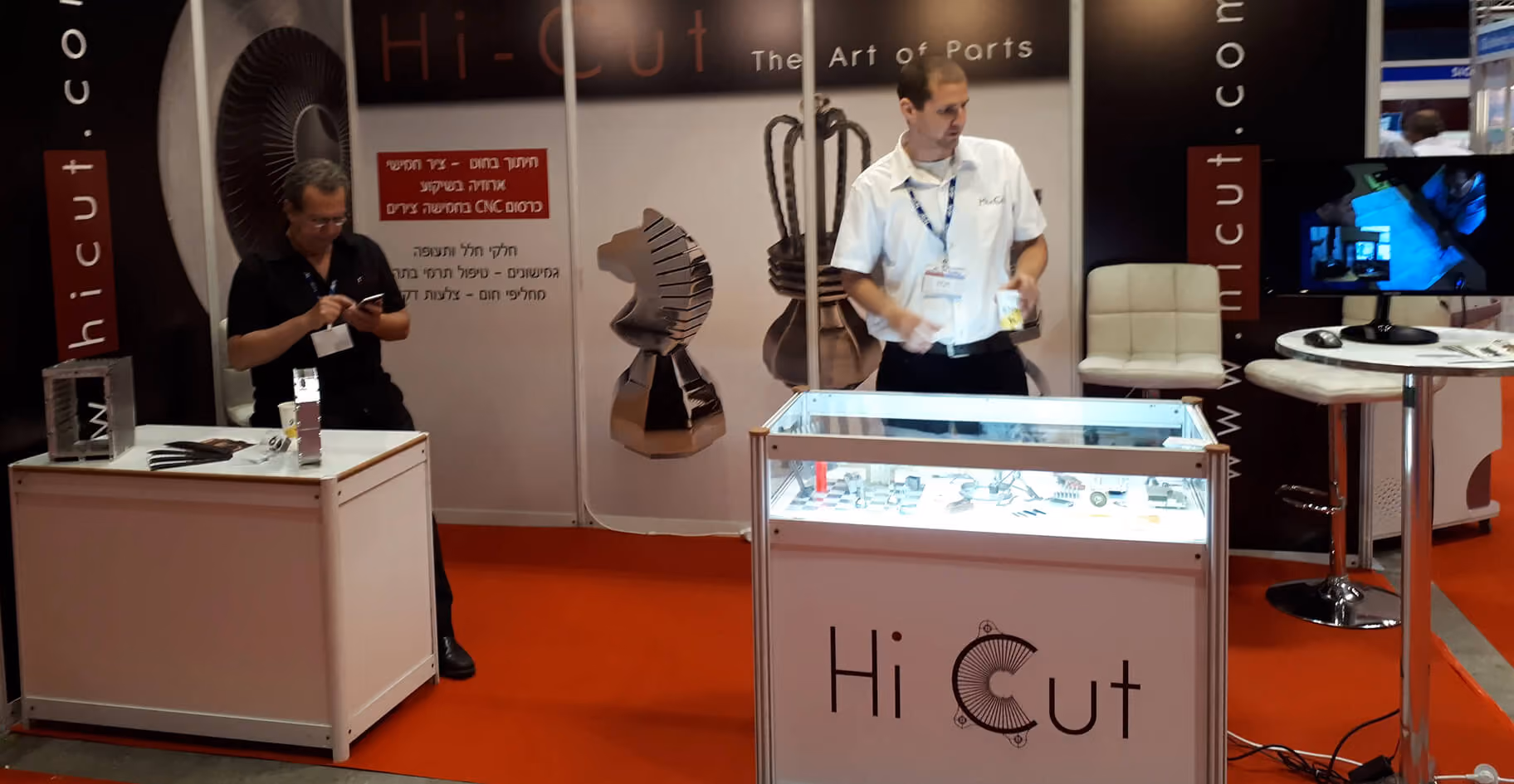 Hi-Cut team at the exhibition booth with parts on display
