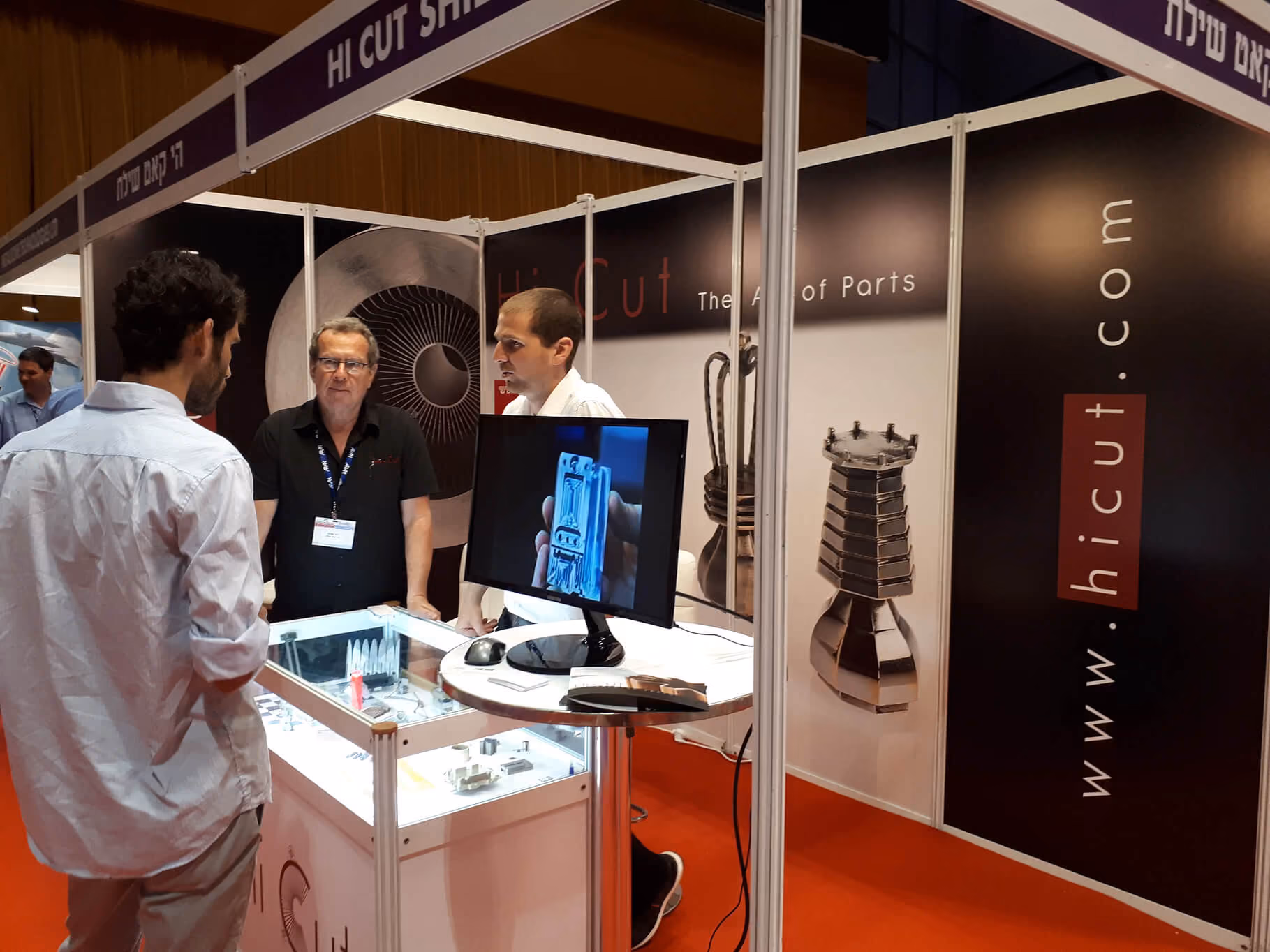 Visitors viewing machined parts at the Hi-Cut exhibition booth