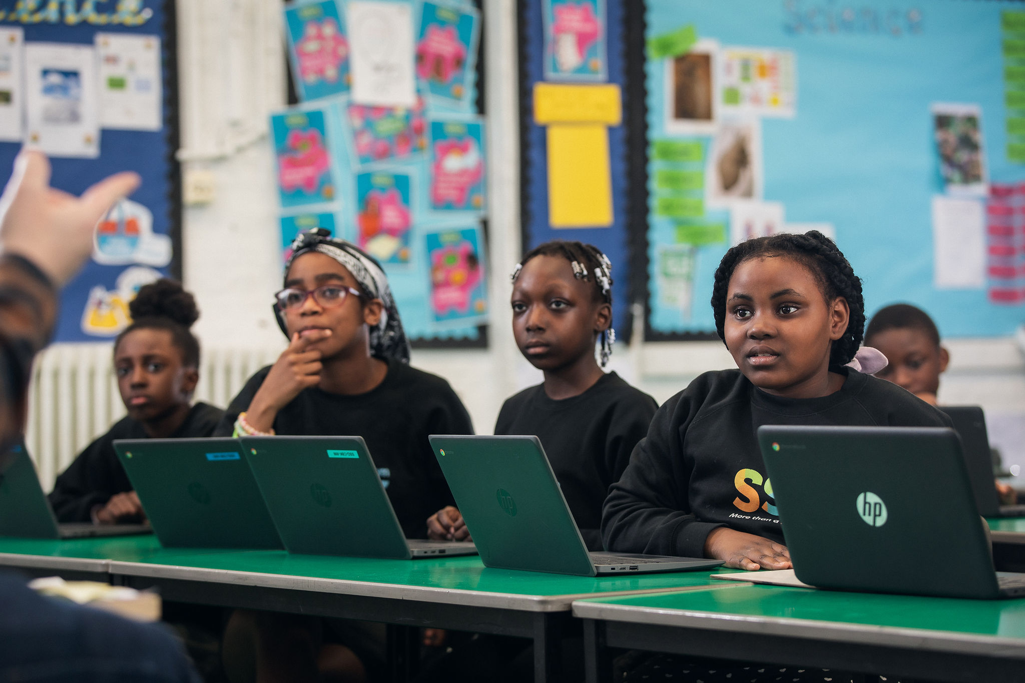 Students sitting at desks with HP Chromebook laptops in a classroom