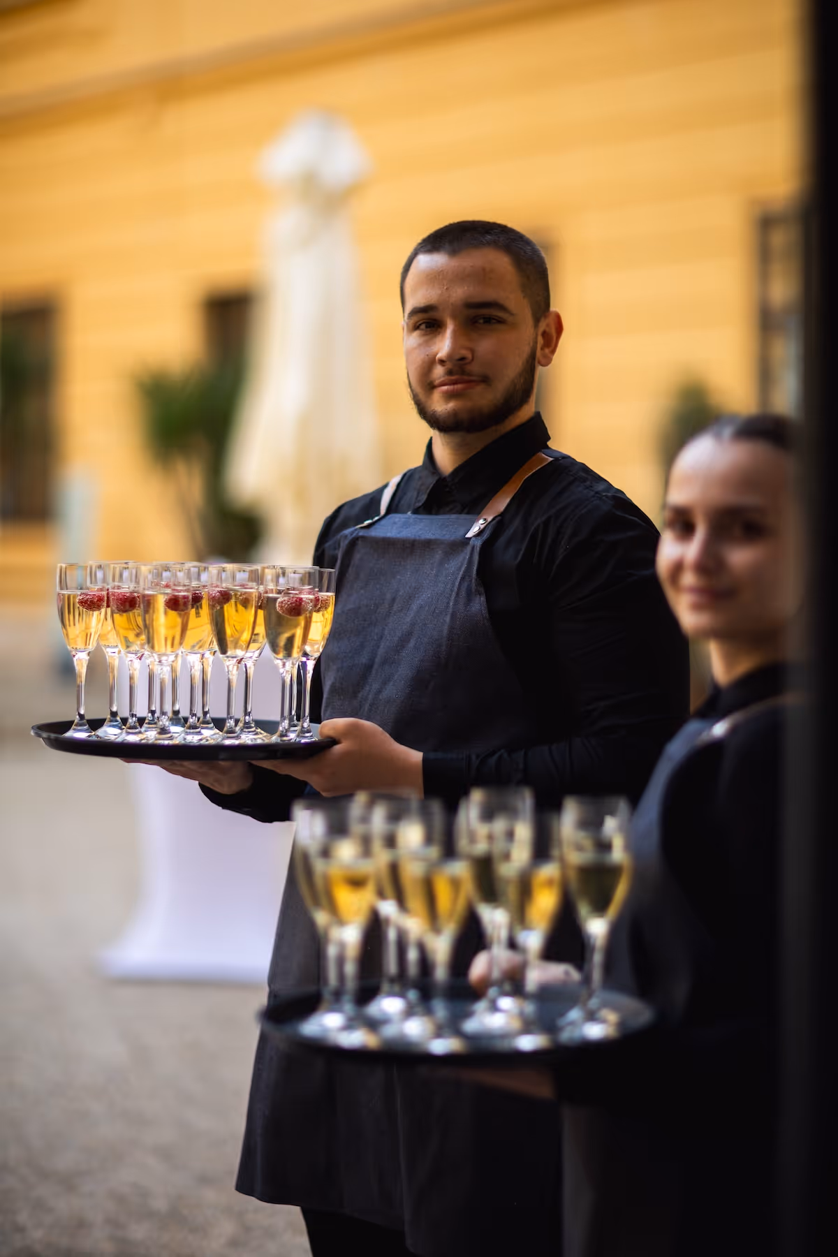 Cateringový personál servíruje prosecco počas svadobnej oslavy