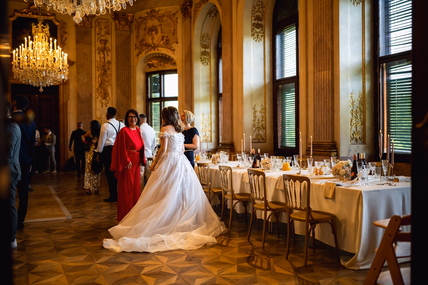 A bride in a historic wedding hall with elegantly set tables for a wedding reception.