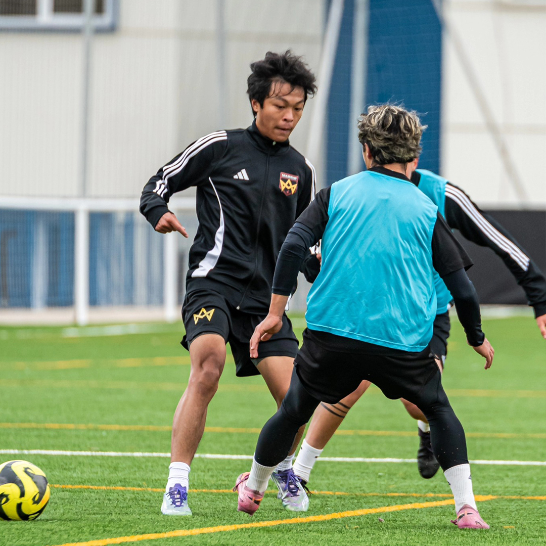 A player from a Spanish soccer academy shoots the ball to the goal.