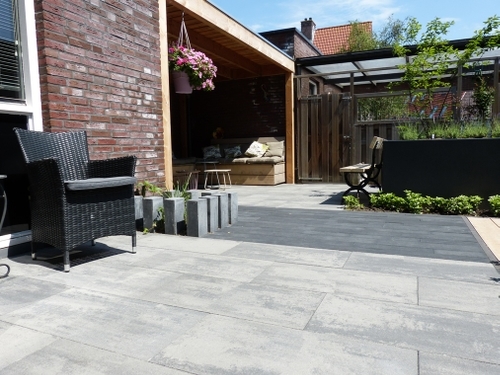 Verticaal geplaatste betonnen stapel elementen geven een speels en toch strak effect aan de border.