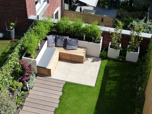Een daktuin in Haarlem met witte verhoogde stuuk-look borders met een geïntegreede lounge bank.