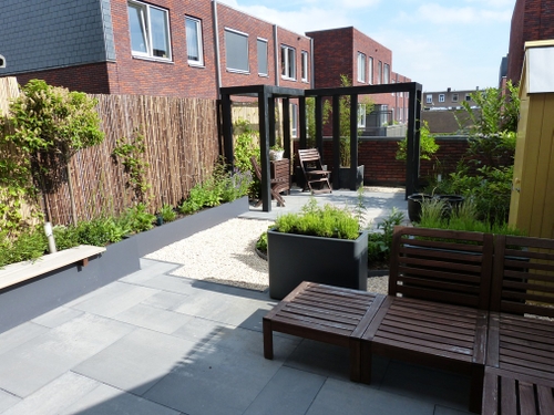 Een pergola, verhoogde borders en een geïntegreerde bank in een daktuin in Haarlem.