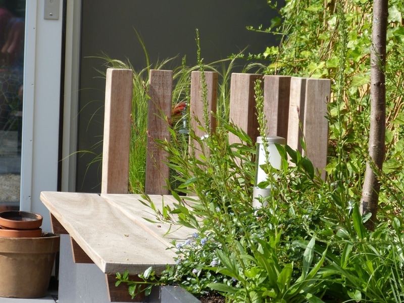 Hardhouten paaltjes als rugleuning voor een geïntegreerde borderbank.