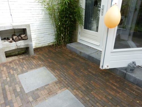 Het hoogteverschil van het huis met de tuin is opgevangen door betonnen traptreden.