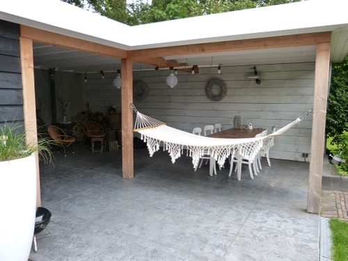 De hangmat onder de veranda is een favoriet plekje in de tuin.