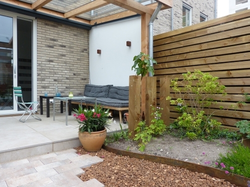 De zijwand van de glazen veranda met glazen dak werd een witte stuuk-look muur.