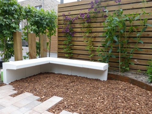 De palen achter dit bankje van wit geschilderde U-elementen dienen als rugleuning.