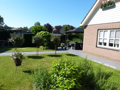 De bol boompjes geven de tuin meer diepte.