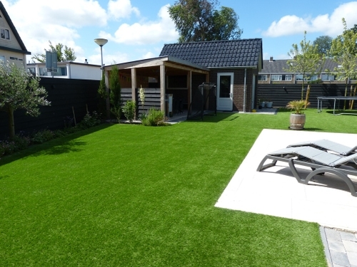 Het natuurstenen terras, kunstgras en overkapping, alles werd zelf gemaakt.