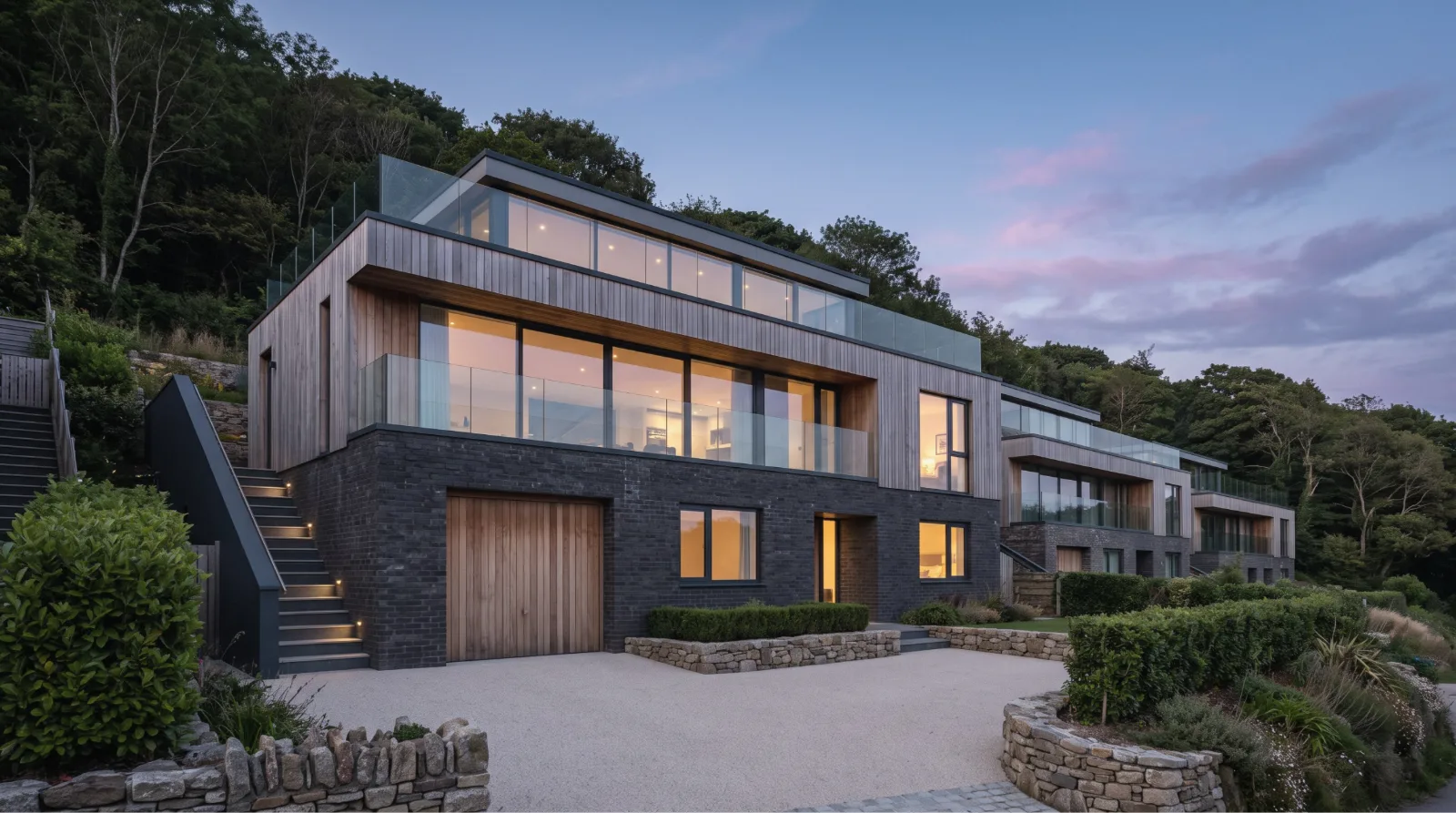 Hillside homes in timber and dark brick at dusk