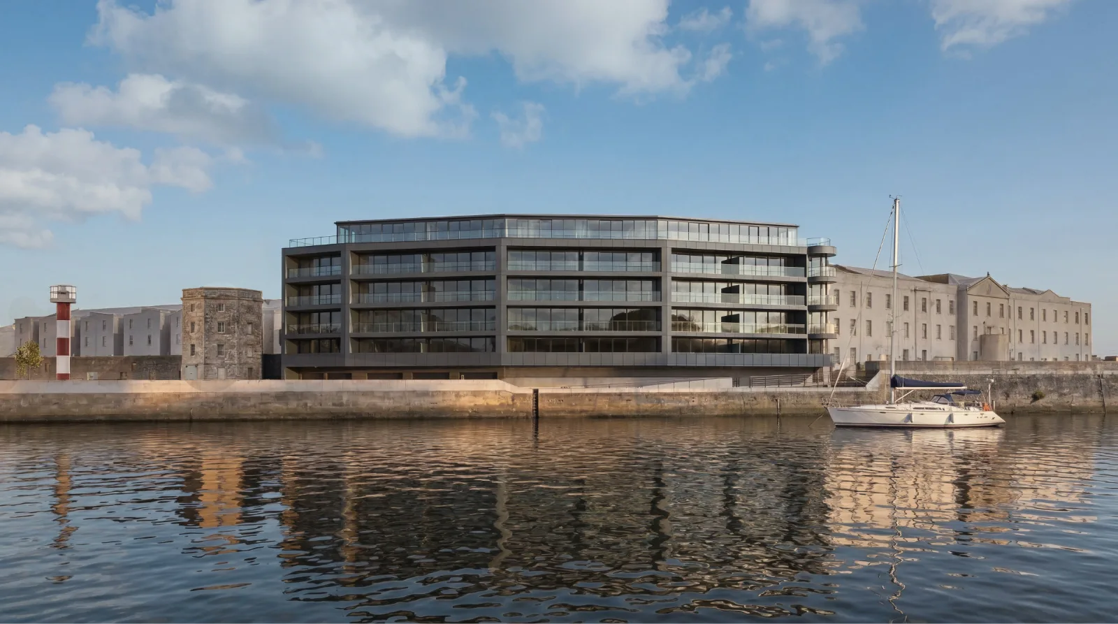 Apartment block on a harbour edge seen across calm water