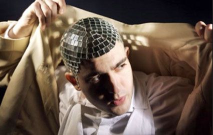 A man uses mirror ball tile on his head for a unique look and identity