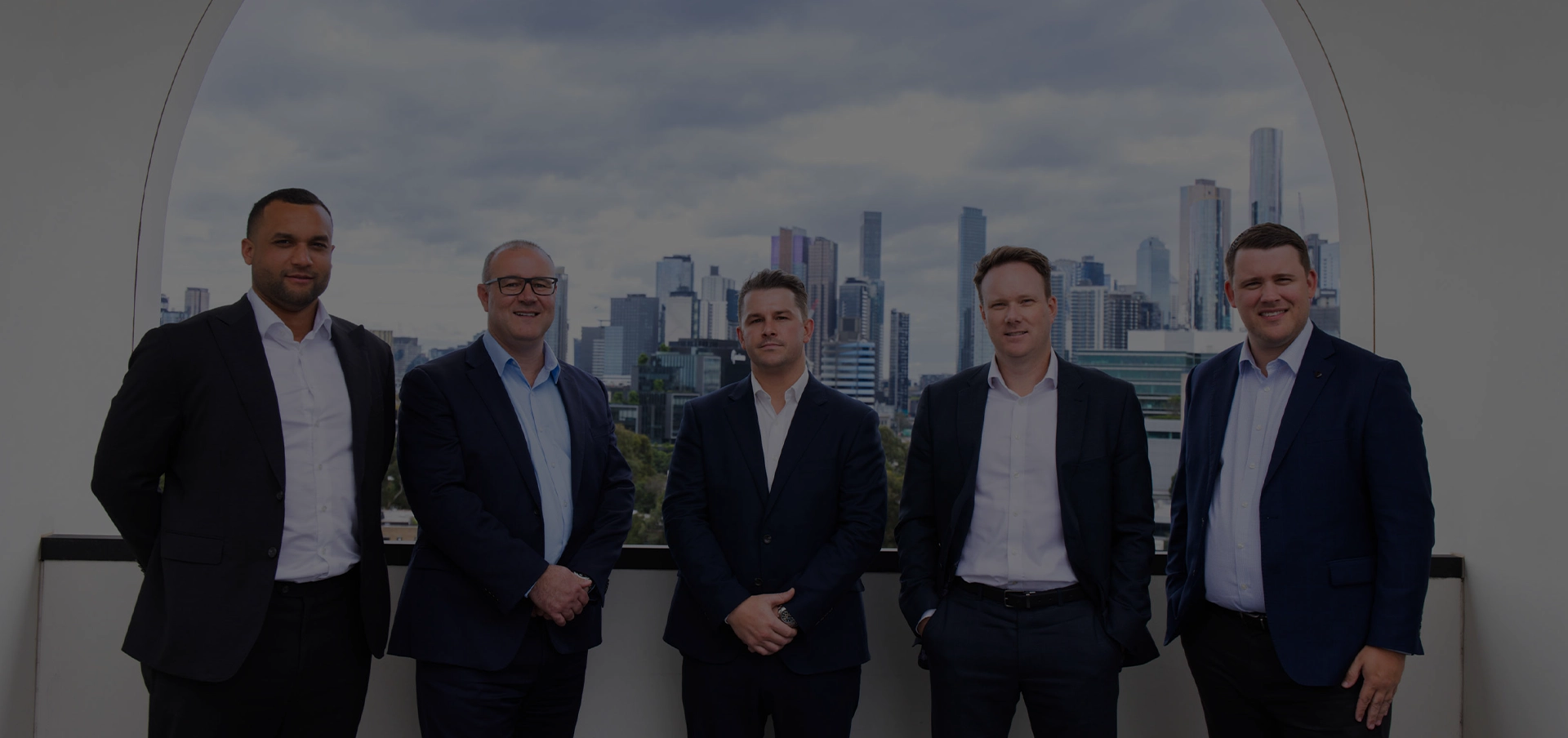 Liston Newton leadership team standing together with the Melbourne skyline in the background.