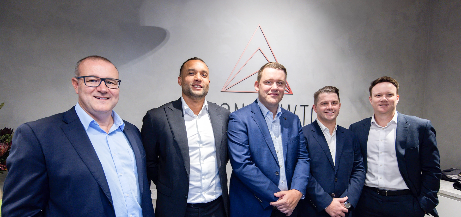Liston Newton Advisory team members posing together in the office reception area.