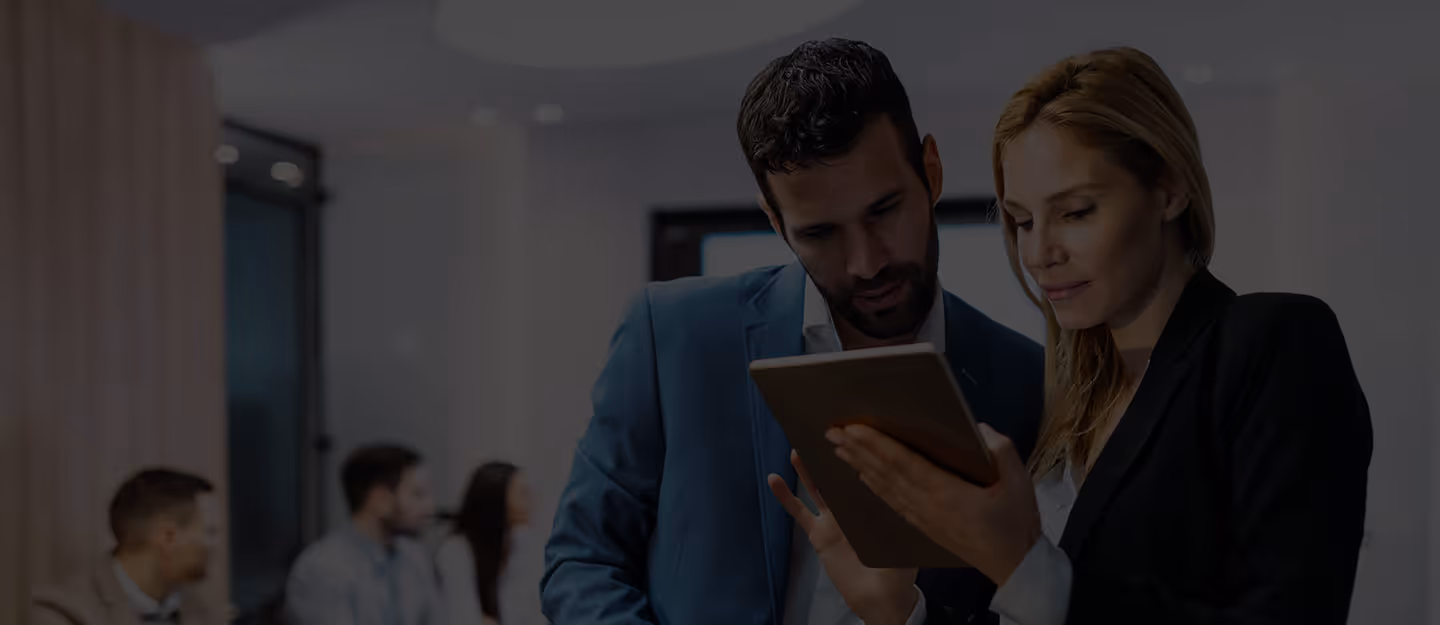 Someone scrolling or typing on a laptop that shows ledgers or dashboards on the screen.