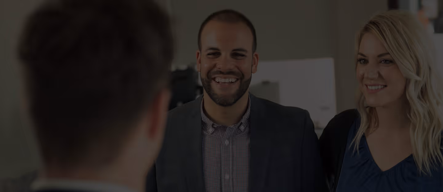 A businessperson standing outdoors with shoulders relaxed and face turned toward the sun.