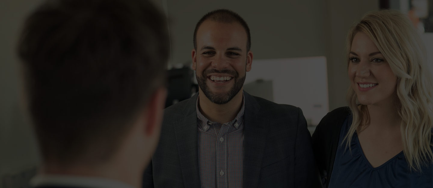 A businessperson standing outdoors with shoulders relaxed and face turned toward the sun.