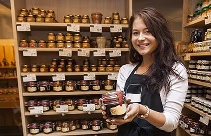 Woman holding jar inside her store