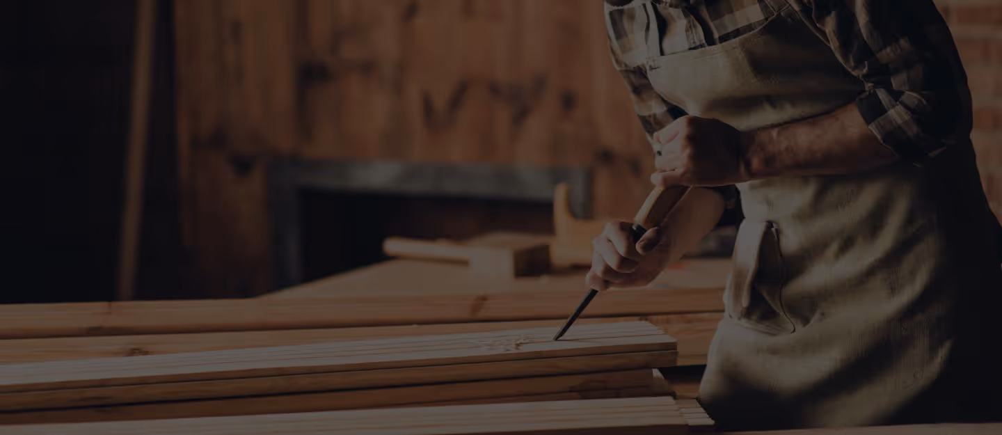 A carpenter kneeling to measure or mark timber on an active building site.