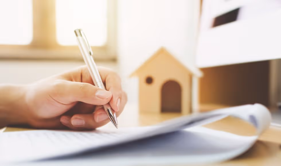 close up of a man's hand signing a contract