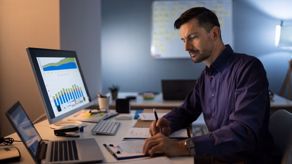 man at desk looking over KPIs